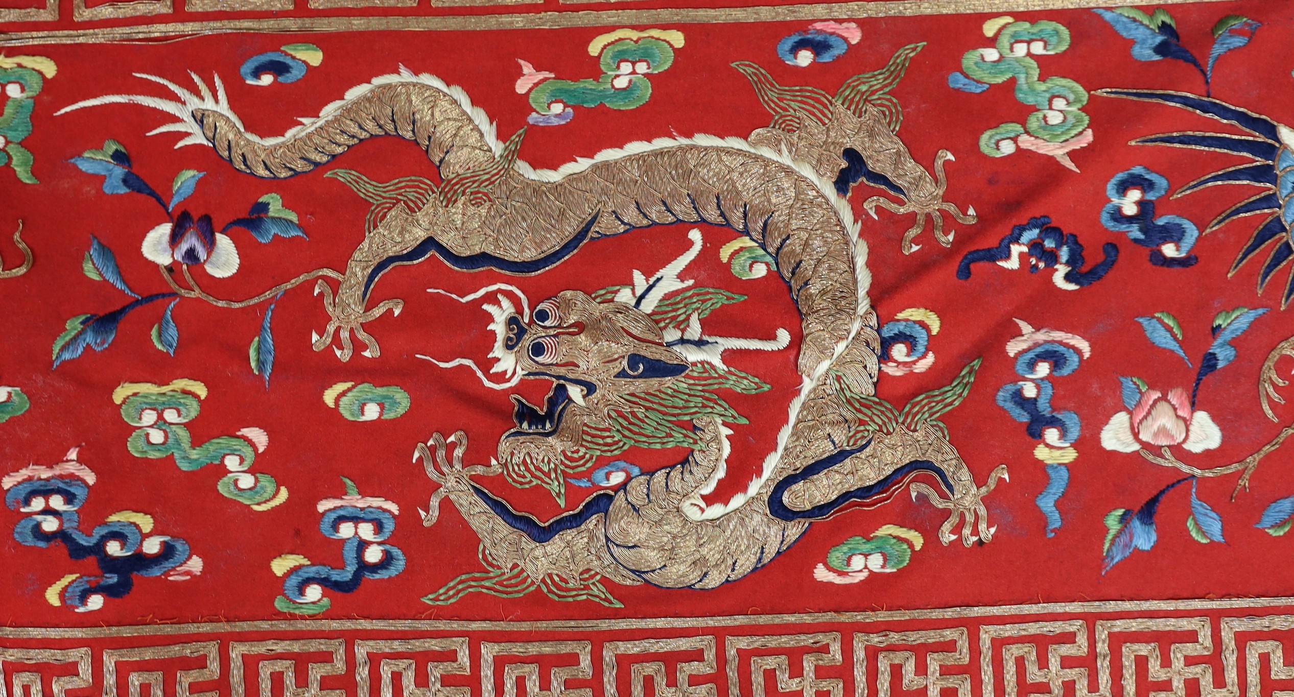 A Chinese embroidered silk ‘dragon, phoenix and lion’ panel or table frontal, late Qing dynasty, 117cm x 337cm